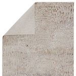 Kimball rug corner folded to reveal backside with muted beige tone and pattern outline