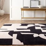Low-angle rug view showing abstract pattern beneath console table with framed art