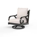 Outdoor swivel rocker chair with curled armrests, plush beige cushions, and black aluminum frame