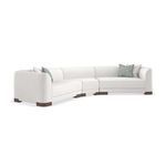 Side angle view showing sectional’s rounded armrest and wood feet in white chenille fabric