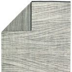 Back side of Farrow rug folded to expose striped reverse pattern in muted gray tones