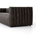 Close-up view of sofa's left side arm showing channeling in vertical leather stripes