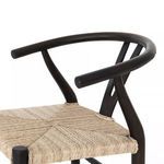 Close-up of curved armrest and top backrest joint over woven wicker seat