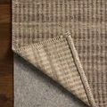 Back side of rug folded to show non-slip rug pad underneath