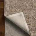 Corner flipped to show the rug backing and protective non-slip pad underneath
