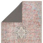 Top left corner of rug flipped to reveal gray grippy backing material
