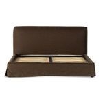 Side view of brown linen slipcovered bed frame without mattress, highlighting base proportions