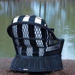 Back view of chair with black and white cushions placed outdoors near a lake