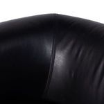 Close-up on curved armrest displaying soft black leather and subtle sheen