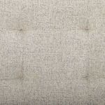 Close-up texture of the tufted headboard upholstery in light beige chenille-like fabric