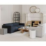 Taffy Accent Table positioned on textured carpet in a living room with wooden coffee table and dark sofa
