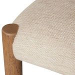 Close-up detail showing seat fabric stretched over rounded oak leg end