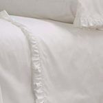 Top view close-up of ruffled edge detail on white cotton percale pillowcase and fitted sheet