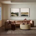 Diptych paintings styled above brown leather sectional sofa and round beige coffee table in modern living room