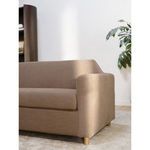 Close-up of sofa arm and upper seat cushion in warm natural light setting
