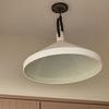 Limoges Grande Pendant in natural rust with aged iron details, inverted conical shade hanging over beige cabinetry