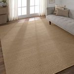 Rug placed in sunlit living room next to grey upholstered sofa with pillows