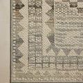 Tight crop of one corner highlights the geometric border woven detail and flat texture