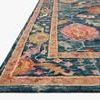 Close-up low-angle view showing the rug’s thickness and texture with rich blue background and warm floral accents