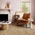 rug styled in a living room with leather chair, side tables, and window showing surrounding space