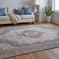Low angled, side perspective of rug laid in a light-filled room with staged sofa and chair