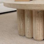 Round coffee table with fluted plinth base made from reclaimed oak wood in natural light finish