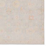 Close-up of rug border highlighting delicate floral motifs and faded pastels