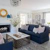 Traditional rug in a living room setting with navy sofas, white fireplace, and layered decor