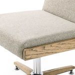 Left profile highlighting curved corner of seat cushion and backrest with light fabric