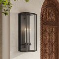 Black Royster Outdoor Wall Sconce with three candle-shaped bulbs and seeded glass mounted beside carved wooden door