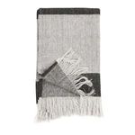 Folded throw showing underside with herringbone weave texture and fringed edge detail
