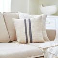 Brett lumbar pillow on beige sofa next to light brown striped pillow and white throw blanket