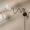 Onda 1 Light Portable Wall Sconce with dual white conical shades and black adjustable zigzag arm