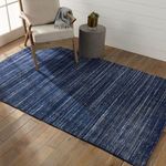 Rug styled in living room with chair and side table on wood flooring