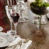 Tabletop close-up with glassware and silverware highlighting wood grain texture