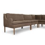 Partial angled view from front showcasing seat cushions and tapered legs extending beyond skirt.