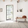 Bellamy Grey Rug in a room setting with wooden chair and wider view showing more wall and decor