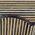 Close-up of ribbed rattan texture and dark grey edging on table surface and scalloped corner