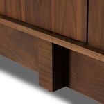 Partial front angle showing door panel edges and base riser in walnut finish