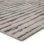 Close-up angled view showing dense tufted wool and viscose fibers with textured black lines on cream background