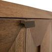 Macro detail of minimal brass pull on dark walnut drawer with visible wood grain texture