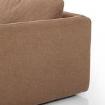 Close-up of armrest’s curved seam and linen fabric texture on sofa