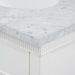 Close-up of marble top corner with distinct grey veining and white lacquer fluted apron beneath