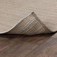 Rug edge lifted to reveal woven underside and thickness on dark wood floor