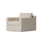 Neutral oatmeal slipcover swivel chair with a boxy shape and thick seat and back cushions