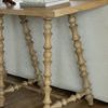 Close-up of Kirkwood Console Table spindle legs and smooth wood grain top in cerused natural finish
