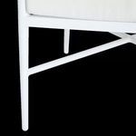 Close-up of white metal sofa leg with crossbar support underneath seating area