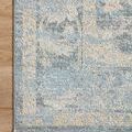 Top corner flat on wood floor showcasing detailed floral and border pattern in blue and beige