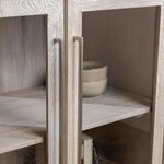 Partial view of cabinet interior with ceramic bowls on top shelf behind glass door
