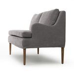 Opposite side angled view emphasizing gentle armrest curve and wood leg tone
